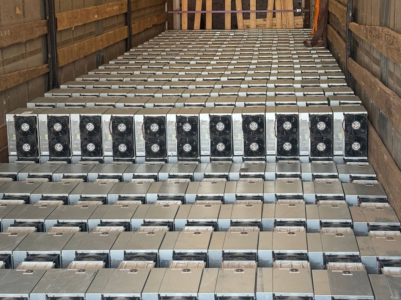 Партия майнеров Antminer S21+ уложена рядами в кузове фуры без упаковки
