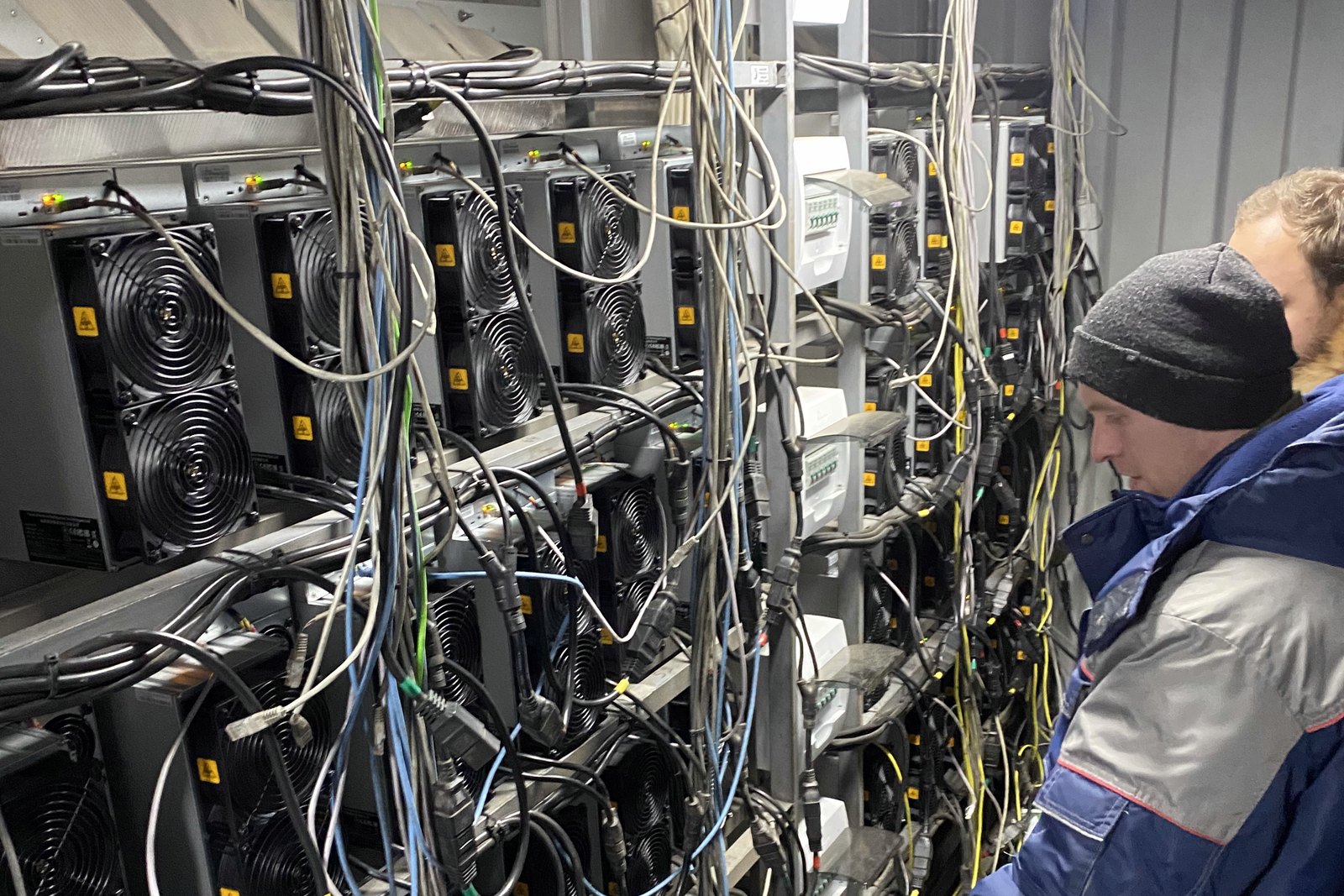 Инженер FastMine обслуживает стойки с ASIC на площадке в Москве — диагностика выполняется на объекте