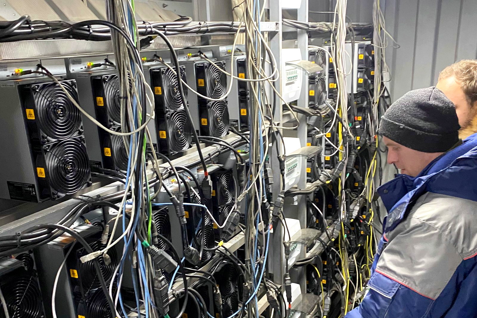 Инженер FastMine обслуживает стойки с ASIC на площадке в Москве — диагностика выполняется на объекте